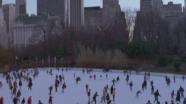从纽约摩天大楼到中央公园的溜冰场和滑冰者。视频素材