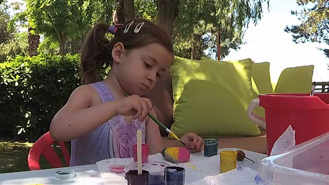 绿色植物，小女孩在院子里画石头视频下载