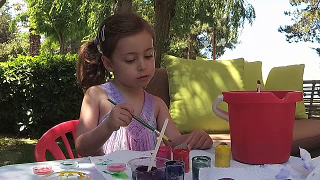 绿色植物，小女孩在院子里画石头视频下载