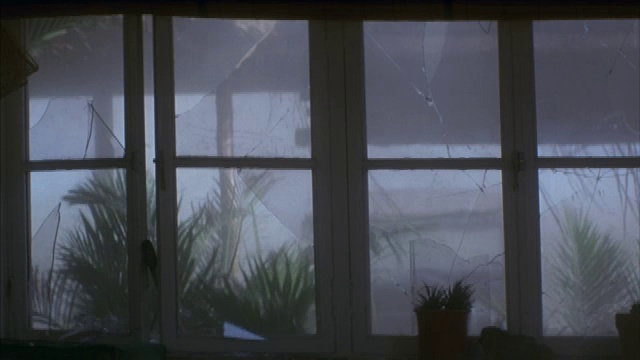 外面沙尘暴肆虐时窗户被打破的中景。视频下载