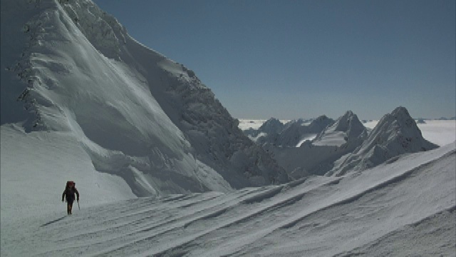 一个在雪山上的登山者的长镜头。视频素材