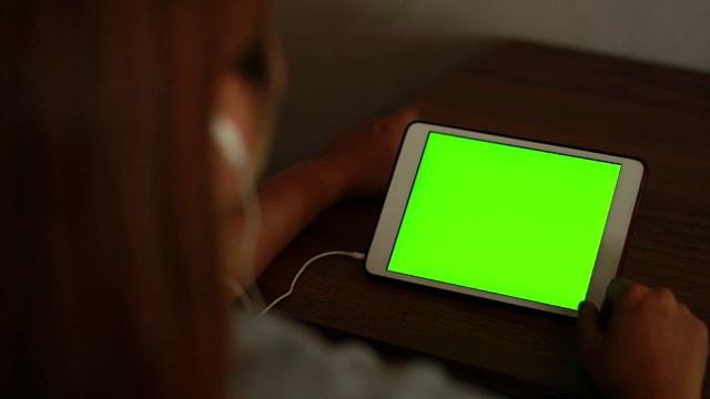 女人看绿色屏幕的平板电脑视频下载