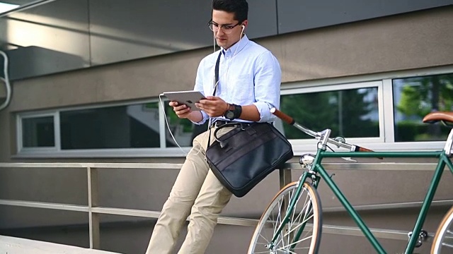 年轻商人用平板电脑骑自行车视频素材