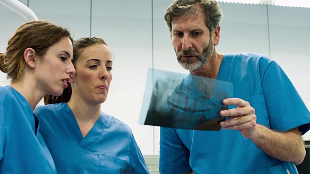 一组牙科医生在牙科诊所寻找x光图像的实时视频视频素材