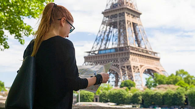 站在埃菲尔铁塔对面的女人，拿着地图探索巴黎视频下载