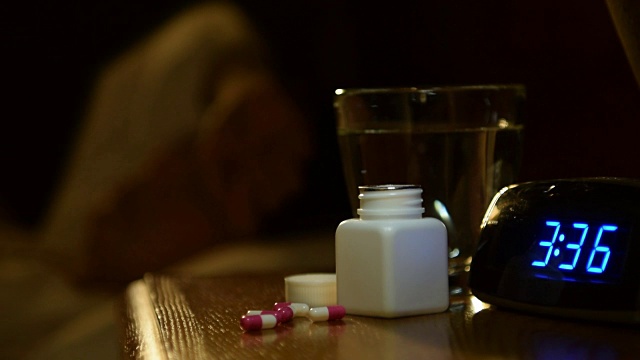 一个女人在床头柜上吃安眠药的录像视频下载