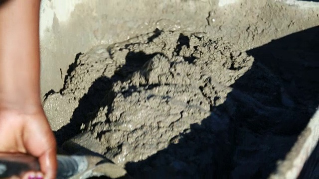 南非开普敦，用铲子在手推车里搅拌混凝土视频下载