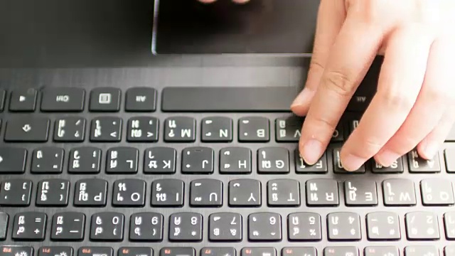 女人的手在键盘上打字的特写，多莉拍摄倾斜下来，时间推移运动视频下载