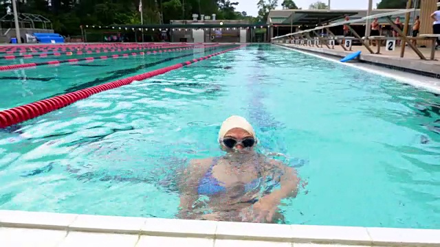 成熟的女运动员在户外游泳池中晨练视频素材