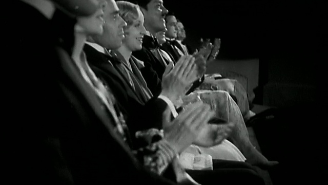 20世纪40年代低角度中镜头一排穿着正式服装的观众/鼓掌视频素材