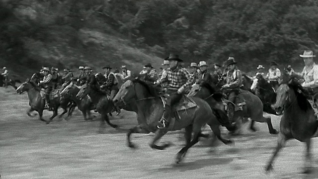 宽镜头跟踪拍摄了一大群骑马冲锋的牛仔视频素材