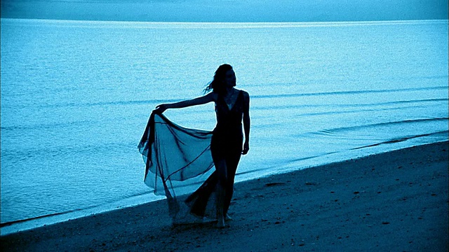 中镜头剪影女人走在海滩黄昏/墨西哥视频素材