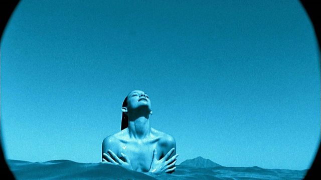 慢动作中镜头裸露上身的女人从水中出来/用手覆盖胸部/吊车拍摄特写视频素材