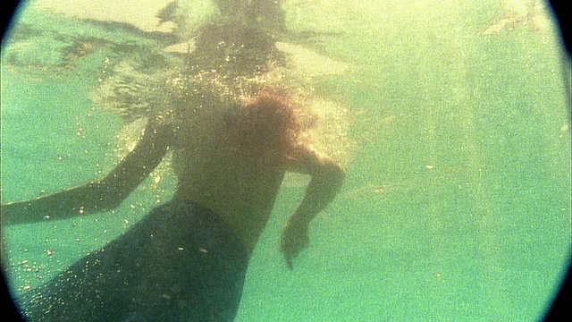 慢动作中镜头半裸女子游泳向水面视频素材