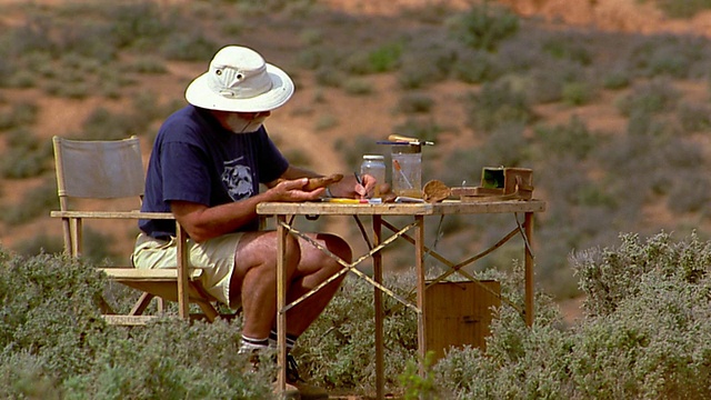 宽镜头考古学家工作与骨头折叠桌子在沙漠视频素材