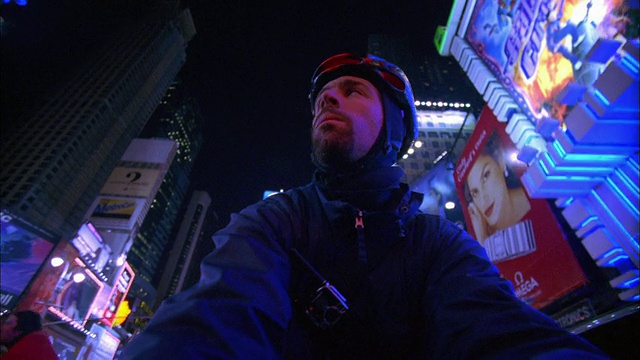 摇摇晃晃的低角度近距离跟踪拍摄的自行车信使在晚上穿过时代广场/纽约视频素材
