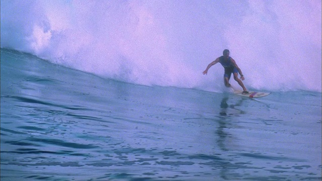 慢动作宽镜头跟踪镜头冲浪者骑在大浪视频素材