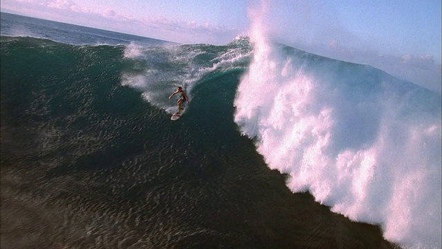 高角度宽镜头跟踪拍摄冲浪者骑在大浪视频素材