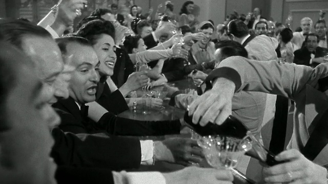 20世纪40年代的广角镜头，一群穿着正式的男男女女在酒吧聊天，大笑/调酒师斟酒视频下载