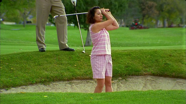 中击女子打高尔夫球从沙坑视频素材
