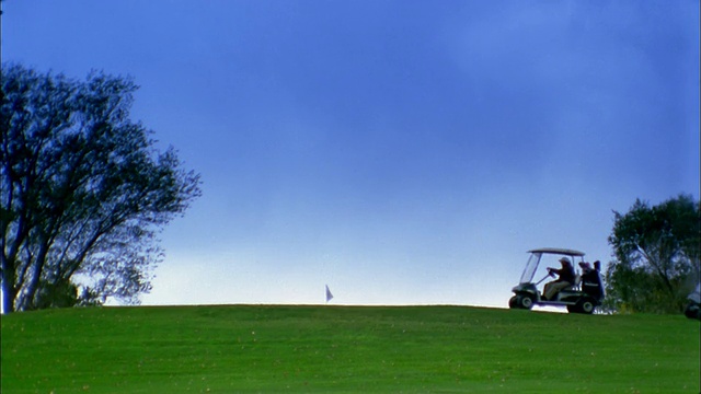 远射人驾驶高尔夫球车在高尔夫球场在地平线视频素材