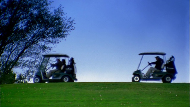 中等射击的人驾驶高尔夫球车沿地平线高尔夫球场视频素材