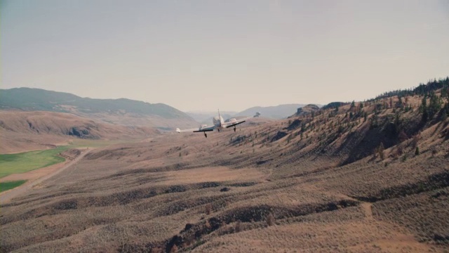 一架塞斯纳(Cessna)通勤飞机起飞前在沙漠跑道上加速，飞过高山和沙漠地带。视频素材