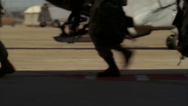 士兵们跑过停机坪，登上一架支努干直升机。视频素材