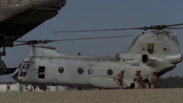 一名士兵坐在支努克军用直升机的货舱门上。视频素材