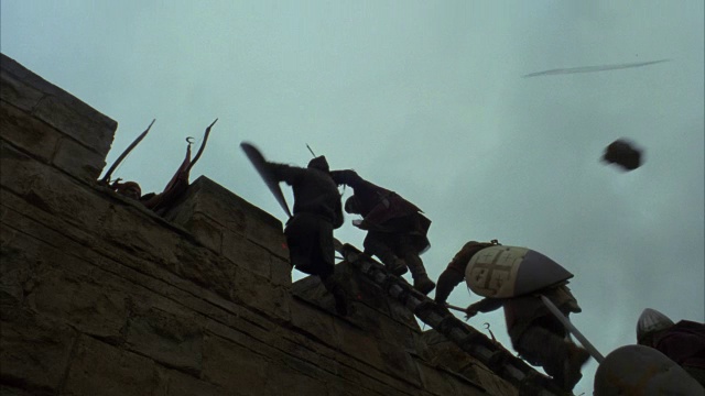 骑士们冲进一座城堡，他们的对手向他们射箭，并把他们从梯子上推下来。视频素材