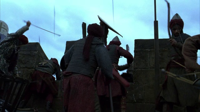 中等角度的战士用斧头在城堡的墙壁上与骑士搏斗，攻占城堡，爬上梯子。可能是宗教十字军东征。武器。箭头。中世纪的。中世纪。视频素材