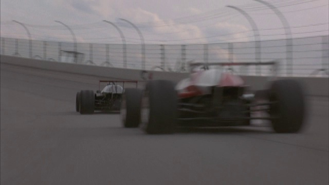 两辆f1赛车在高速公路上的一个转弯处超速行驶。视频下载