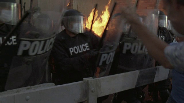 人群与身着防暴装备的警察发生冲突。视频下载