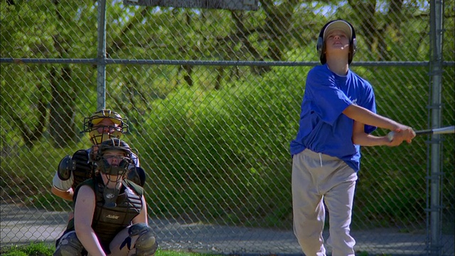 近镜头缩小女孩挥棒和击中棒球比赛中的球视频素材