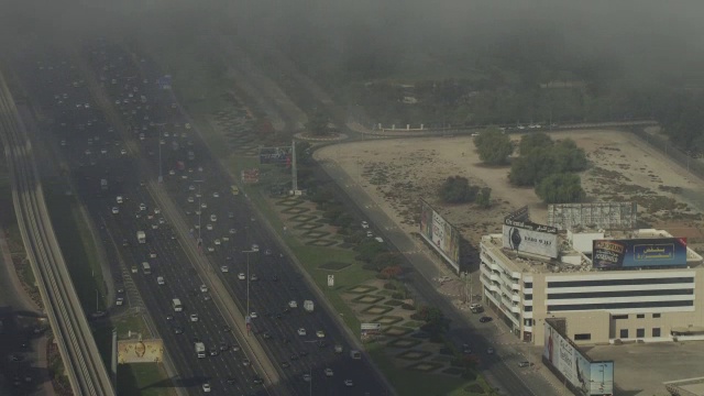 一层一层的雾漂浮在迪拜谢赫扎耶德公路和迪拜塔的上空视频下载