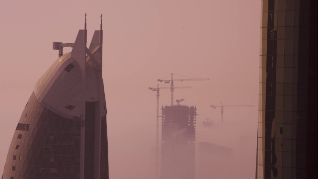 雾在摩天大楼和建筑起重机之间漂移，迪拜视频素材
