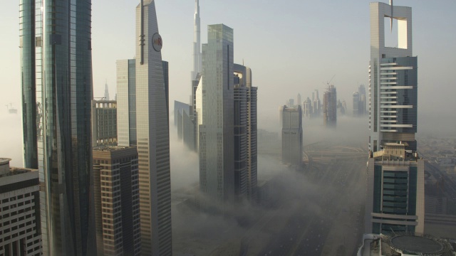 迪拜，一层一层的雾在建筑物之间和谢赫扎耶德公路上飘过视频素材