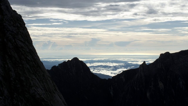 在婆罗洲基纳巴卢山的岩石山峰上，时间推移的云翻腾视频素材