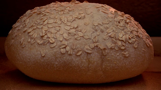 近距离拍摄一段时间，上面有燕麦的圆面包，在烤箱中烘烤，发酵，并变成棕色视频素材