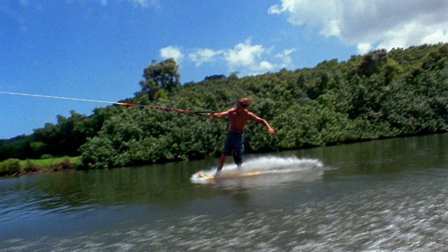 慢动作船视角的人骑尾水板，在空中翻转和在水上降落/考艾岛，夏威夷视频下载