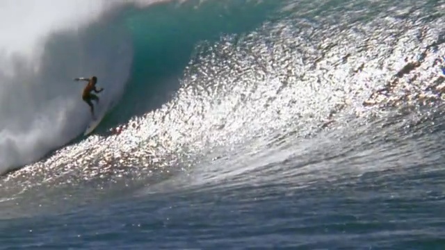 慢动作宽镜头男性冲浪者骑在大浪/骑在波浪内/瓦胡岛，夏威夷视频下载