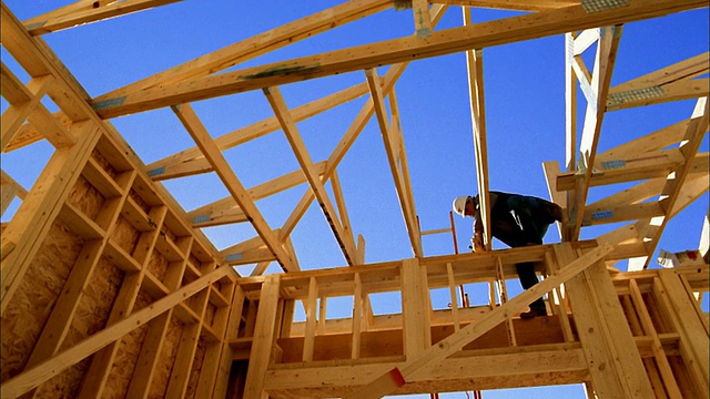 低角度中景建筑工人锤打房屋框架/凤凰城，亚利桑那州视频素材