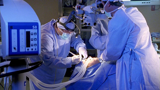 中枪三名外科医生在医院对病人的头部进行手术视频素材
