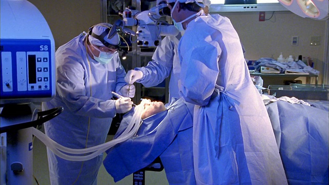 近三名外科医生在医院对病人的头部进行手术视频素材