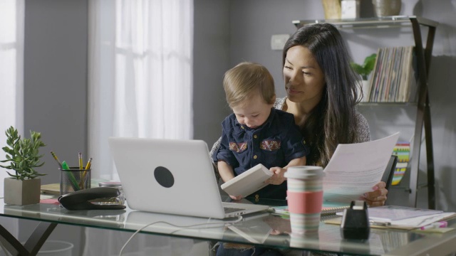 中等平移拍摄母亲和儿子在桌子上工作的大腿/雪松山，犹他州，美国视频素材