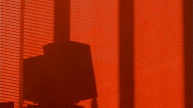 时光流逝的阴影和橘色的灯光照在空荡荡的办公室墙上视频素材