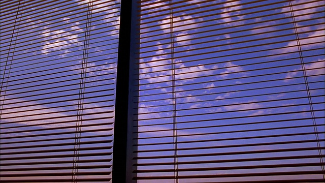 摄影车透过办公室窗户的百叶窗拍摄蓝天白云视频素材