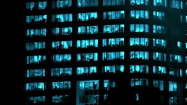 晚上，在窗户上有蓝灯的情况下，潘和办公大楼等着视频下载