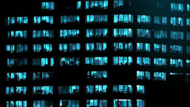 中景，办公大楼夜间，窗户有蓝色灯光视频下载