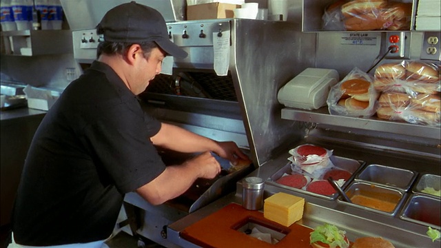 中速厨师从快餐店厨房烧烤芝士汉堡视频素材